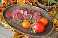 Dry salami sausage sliced Ã¢â¬â¹Ã¢â¬â¹on a wooden board and covered with spices, tomatoes. Russian cuisine Royalty Free Stock Photo